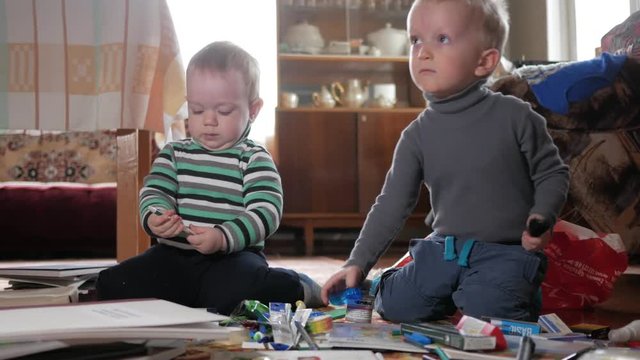 Two boys play at home with stationery. Cute brothers spend interesting time