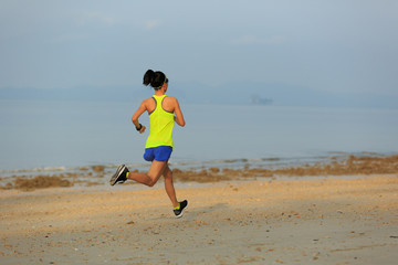 Healthy lifestyle young fitness woman running at morning beach