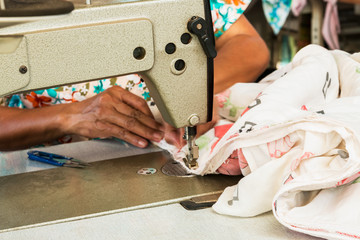 Industrial sewing machines with workers being sewn.