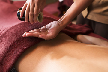 Hand pouring oil for massage in spa