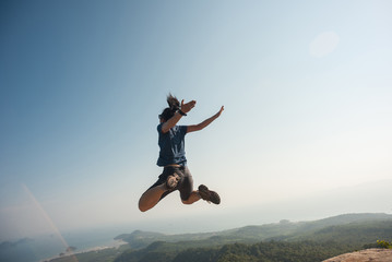 Fototapeta na wymiar jumping on rocky mountain peak, freedom, risk, challenge, success concept