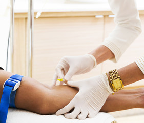 Nurse hand injecting medicine to patient arm