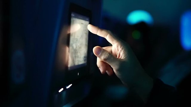Passenger hand using airplane in flight entertainment touch screen to see flight detail map