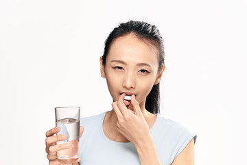 a woman drinks a pill with water