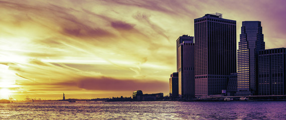 Panoramic sunset over Wall Street and the Statue of Liberty