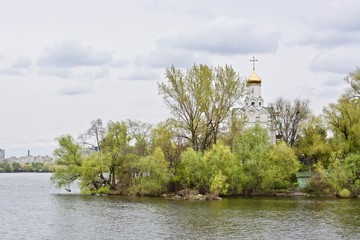 Fototapeta na wymiar Church in the park with green trees