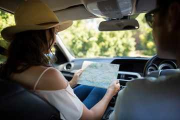 Young woman reading map in car