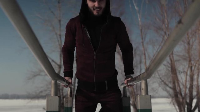 Young athletic adult doing triceps dips on parallel bars