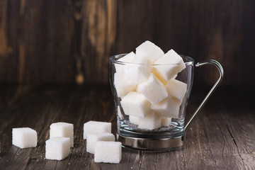 Excessive portion of sugar in mug with tea