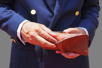 Business man taking notes out of his purse on a gray background.