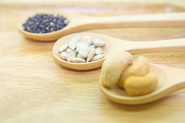 sunflower kernels and black sesame and cashew nuts on spoon