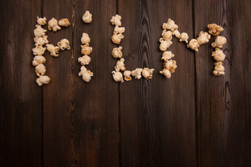 popcorn on a wooden background, word