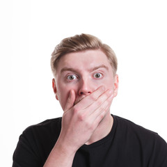 Gossiping, surprised man covering mouth with hand