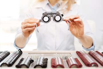 Lovely diligent optician suggesting trial spectacles