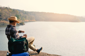 Fototapeta premium Happy Asian hipster man backpack in nature background, Relax time on holiday concept travel , color of vintage tone and soft focus