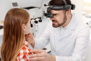 Concentrated competent expert examining girls eyes