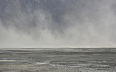 two people in front of a dust storm at dry territory