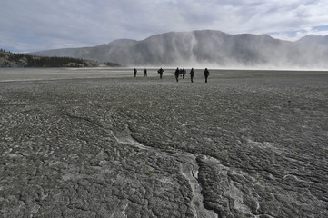 group of people in front of a dust storm at dry territory