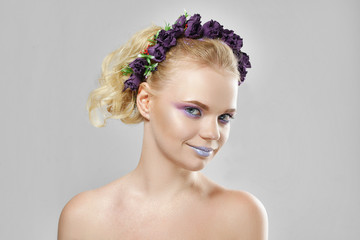 Fashion beauty model girl with flowers in her hair. Perfect creative make up and floral art hairstyle.