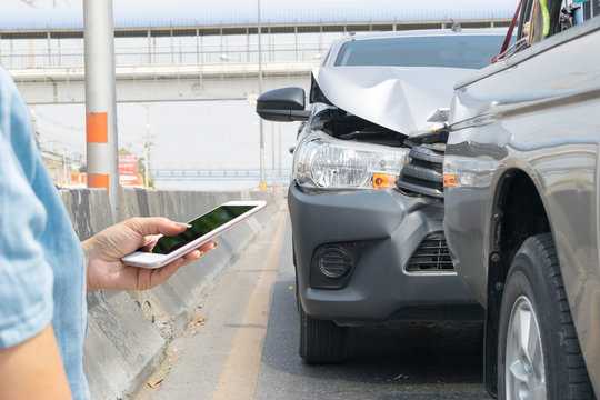 Car crash from car accident on the road in a city car pickup wait insurance smartphone call a car insurance