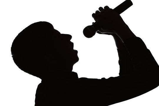 Silhouette portrait of a man sings into a microphone