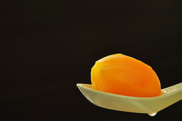 Marian plum tropical fruit in syrup on spoon