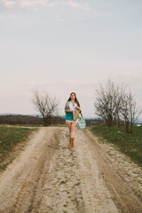 Obraz premium Hipster girl standing on a dirt road