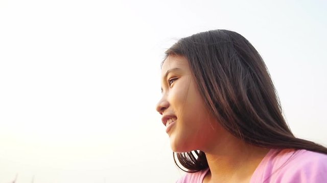 Happy little girl looking up at sky in sunset, Slow motion
