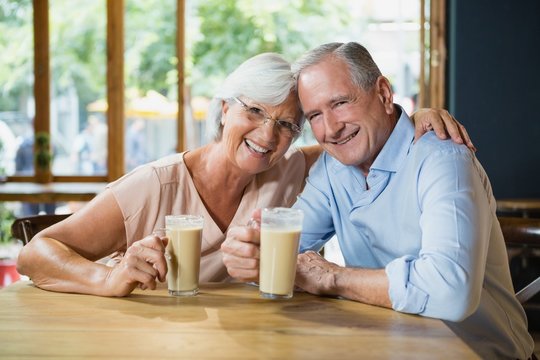 Portrait of happy senior couple having cold coffee