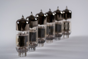 Row  of old glass vacuum radio tubes on white background. Selective focus