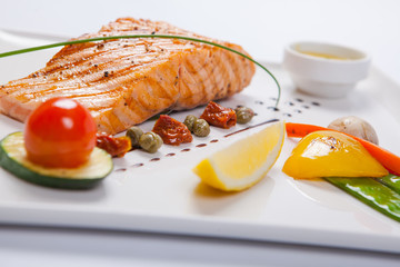 Grilled salmon and vegetables on the white plate
