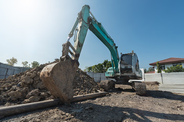 Fototapeta na wymiar excavator on construction site, digger on gravel heap with shovel