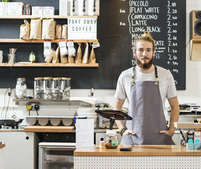 Portrait of a young man behind a counter in a cafe