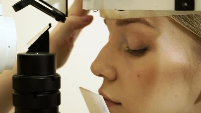 Professional oculist examining and treating eyes of an young attractive woman. HD