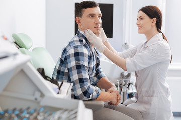 Delighted female otolaryngologist sitting opposite her patient