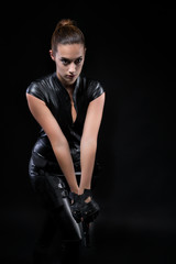 Fototapeta na wymiar Superhero police woman in a leather catsuit with guns