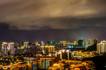 Fototapeta na wymiar Night cityscape with clouds illuminated with city lights. Sanya town, Hainan Island of China.