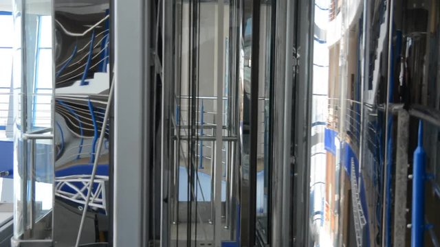 Move the elevator up and stop in a large business center. Modern metal elevator