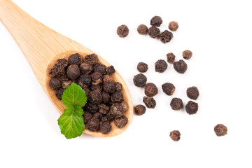 Black peppercorn in a wooden spoon isolated on white background. Top view