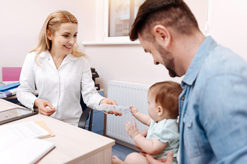 Obraz premium Little joyful patient sitting on father legs
