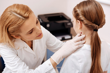 Obraz na płótnie Canvas Attentive pediatrician examining birthmark on the neck