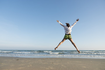 Obraz premium Happy young asian woman jumping on the beautiful beach in Thailand.
