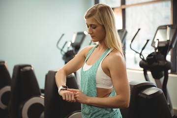 Young fit woman using smartwatch