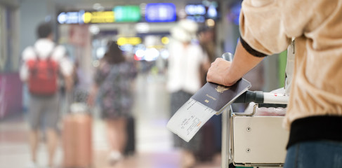 Closeup of girl holding passports and boarding pass at airport
