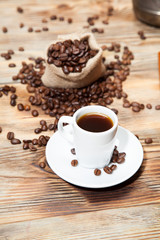 Fototapeta premium cup of coffee with grains on the wooden background