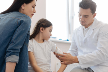 Fototapeta premium Handsome professional doctor examining his patient