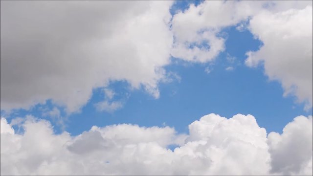 White clouds move across clear blue sky. Cloudy blue sky background.