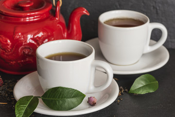 tea concept/tea pot, cups of tea, tea leaves on slate