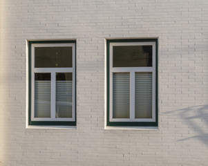 Zwei Fenster in einer weißen Fassade