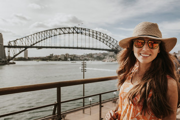 Happy girl in front of Sydney Harbour Bridge, Australia.